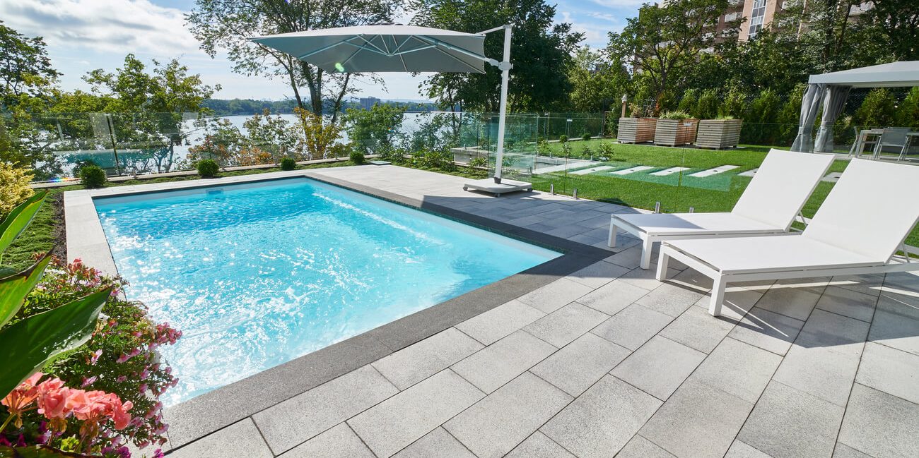 Unilock pool patio with glass safety fence