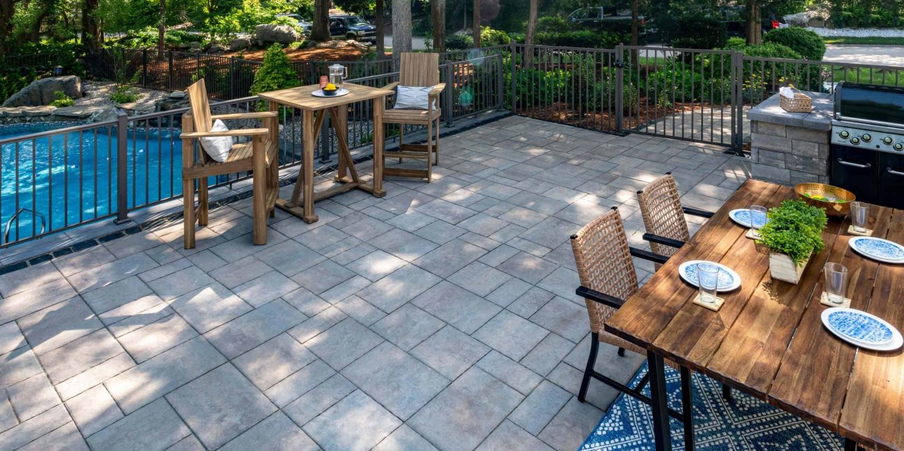 Unilock backyard paver patio with metal fence